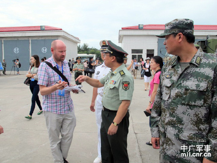 The picture shows Geng Yansheng, director of the Information Office under the MND, communicates with a reporter from the Reuters.