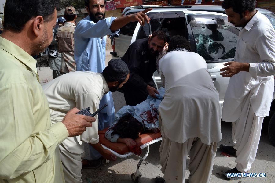 People remove a body from the firing site in southwest Pakistan's Quetta on July 31, 2013. At least three people were killed and five others injured as unknown gunmen opened fire on a vehicle at Prince Road in Quetta on Wednesday, local media reported. (Xinhua/Asad)