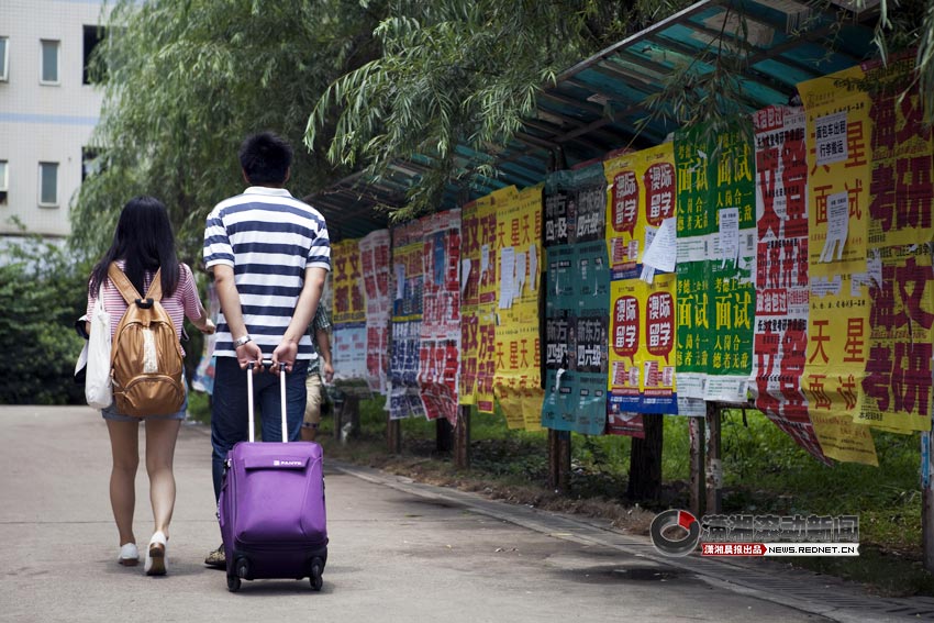 Liu Tongwei helps Wu Jia drag the trunk after leaving the dorm, June 22, 2013. (XiaoXiang Morning Herald/Jiang Limei)