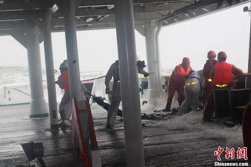 The rescue effort is going on against the strong wind and surge brought by the Typhoon Utor. (Chinanews/Kang Le)