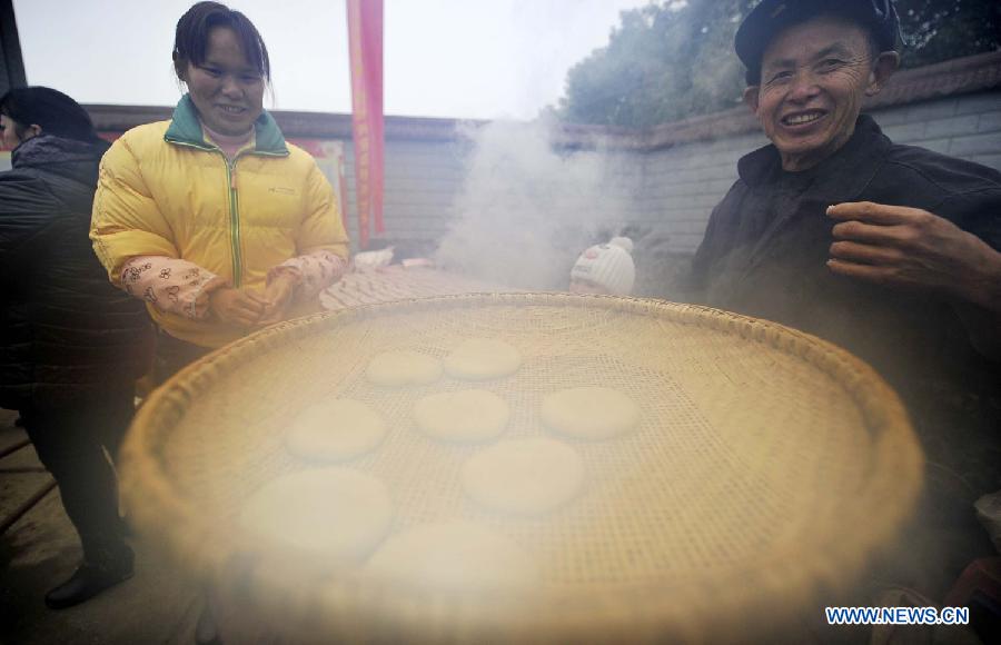 Local people make "Ciba", a special glutinous rice cake for Chinese Spring Festival, during a folk culture show in Zhangjiajie, central China's Hunan province, Jan. 18, 2014. (Xinhua/Zhao Ying)