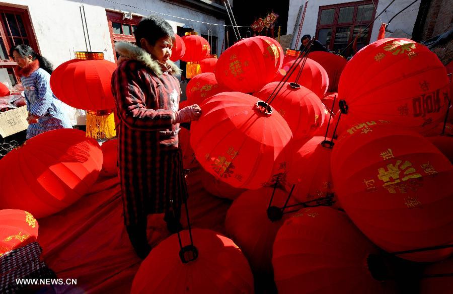 A villager settles the newly made red lanterns at the Xubeizhang Village in Wenxian County, central China's Henan Province, Jan. 20, 2014, to prepare for the upcoming Spring Festival, which falls on Jan. 31 this year. (Xinhua/Zhu Xiang)  