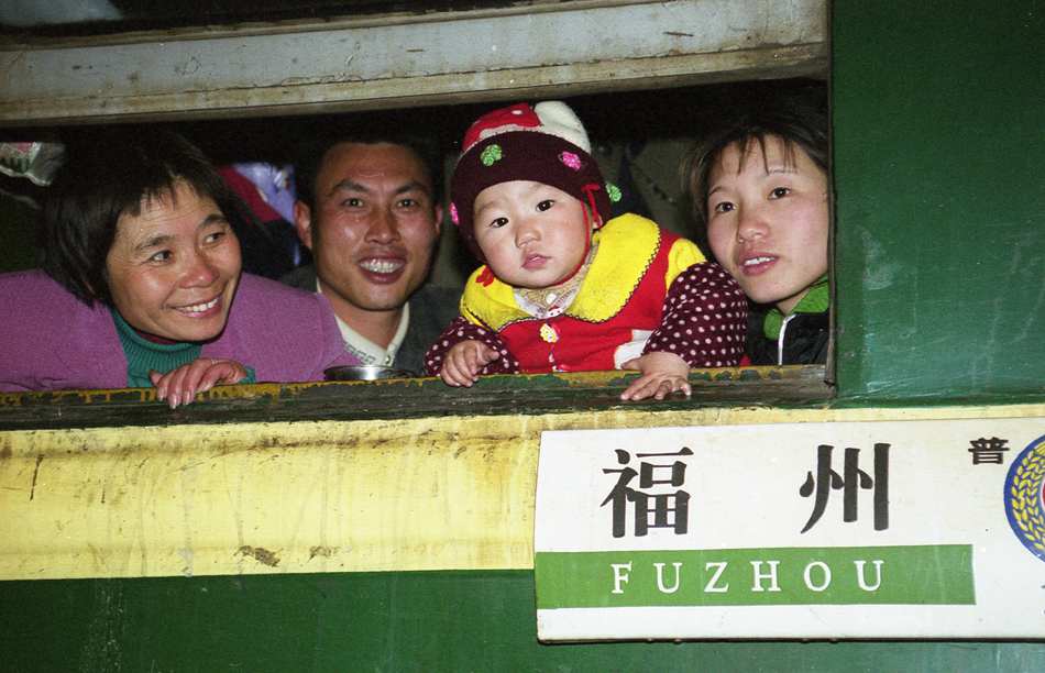 A family looks through the window of the train. The photo was taken by Deng Bo in the Spring Festival Rush in 2002. (Copyrighted picture/ Reprint is prohibited)