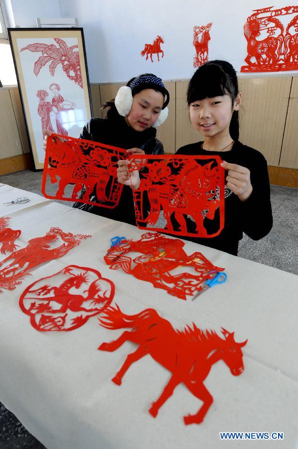Students of the Beileng Village Primary School demonstrate equine-themed Chinese paper cuttings, which were made to mark the upcoming Year of the Horse, in Wenxian County, central China's Henan Province, Jan. 20, 2014. A traditional art form that dates back to the Eastern Han Dynasty (25-220 AD), paper cutting remains popular in modern China, especially around the Lunar New Year, which falls on Jan. 31 this year. (Xinhua/Zhu Xiang) 