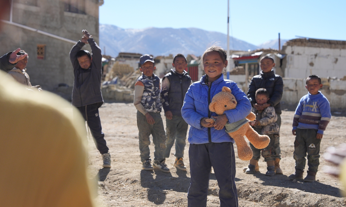 A social worker presents toy to children in a resettlement site in a village of Dingri county, Xigaze, in southwest China's Xizang Autonomous Region on January 8, 2025. Photo: Xinhua