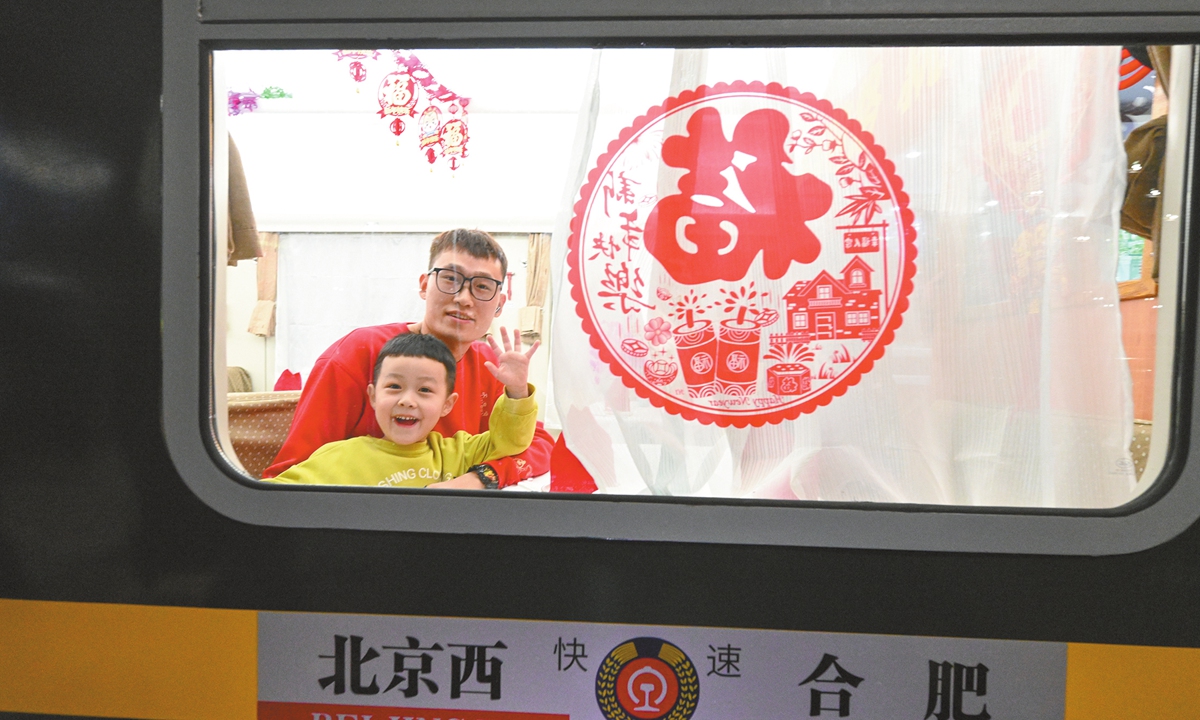 A father and son wave to the camera on train K4159 before it departs from Beijing West Railway Station for Hefei, East China's Anhui Province, on January 14, 2025. China's annual Spring Festival travel rush, also known as chunyun, officially started on the same day and will last until February 22. Photo: Chen Tao/GT