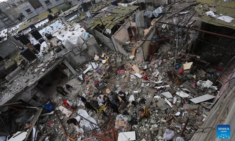 People are seen among the rubble of buildings destroyed in an Israeli airstrike in the southern Gaza Strip city of Rafah, on Nov. 15, 2023. Israel has been carrying out attacks on Gaza over the past weeks and has imposed a siege on the enclave to retaliate against Hamas attacks on southern Israel. The conflict has so far led to the deaths of over 11,500 Palestinians in Gaza.(Photo: Xinhua)