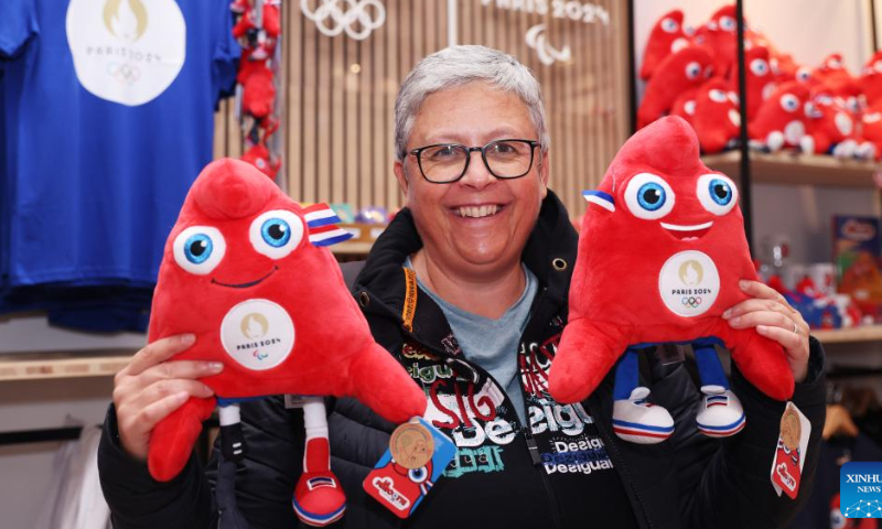 A customer poses with licensed products at the first Paris 2024 official flagship store in Paris, France, Nov. 15, 2022. Photo: Xinhua