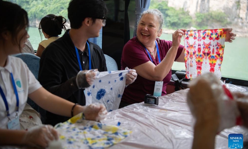 Participants taking part in a China-U.S. youth exchange program experience tie-dye on board an electric tourist ship in Yichang, central China's Hubei Province, June 11, 2024.(Xinhua/Du Zixuan)