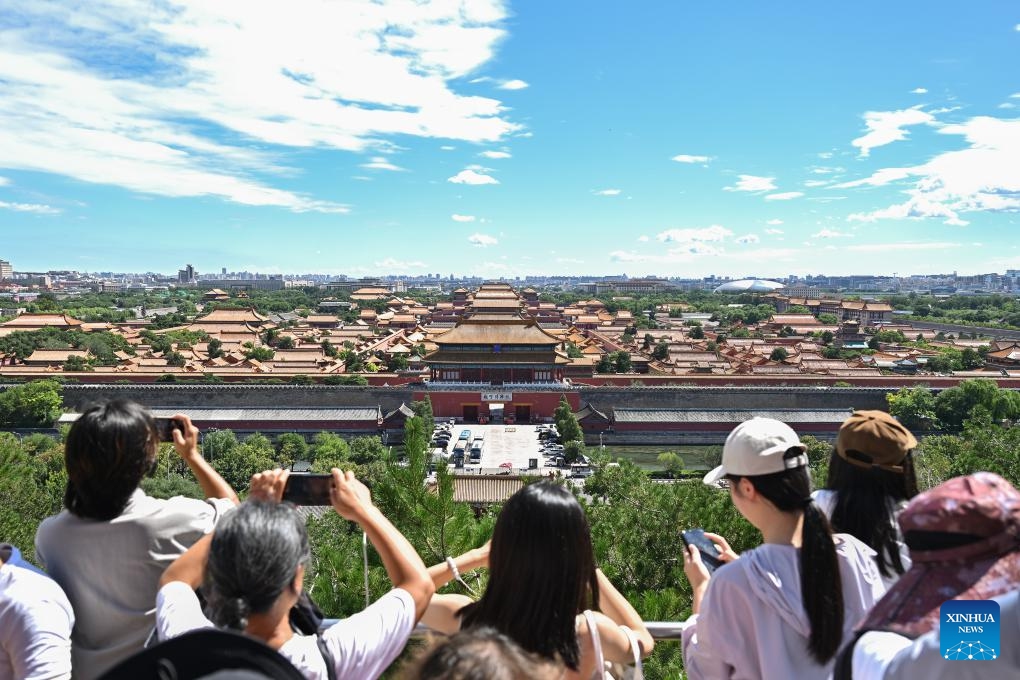 Tourists take pictures of the Palace Museum from Jingshan Park on a sunny day in Beijing, capital of China, Aug. 12, 2024. （Photo: Xinhua)