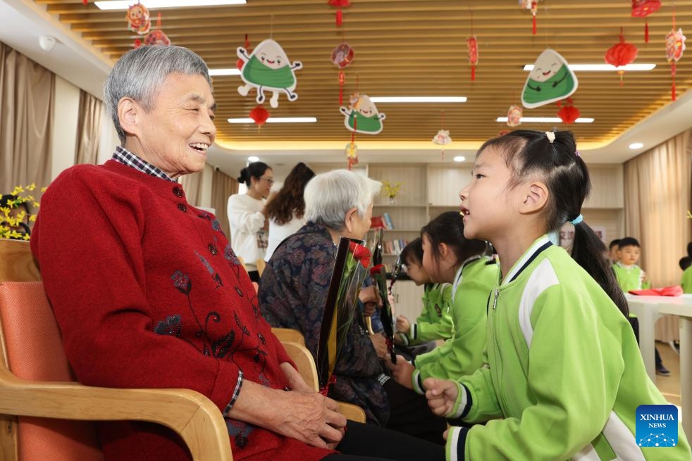 Children tap the legs for local seniors at an elderly care center in Deqing County of Huzhou City, east China's Zhejiang Province, Oct. 10, 2024. A series of celebration activities were held across the country to mark the country's Seniors' Day, which falls on Oct. 11 this year (Photo: Xinhua)