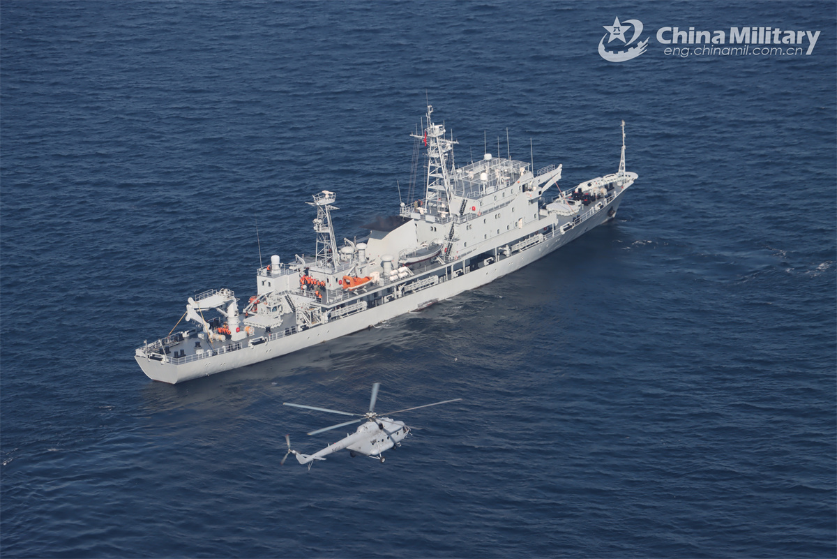 Naval ship and air force helicopter in joint search and rescue training